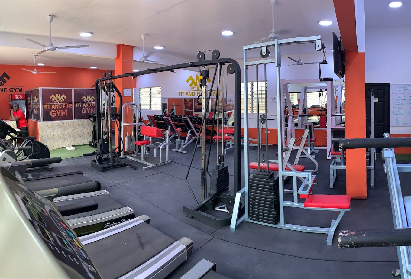 Wide view of the gym floor with exercise equipment and reception in the background